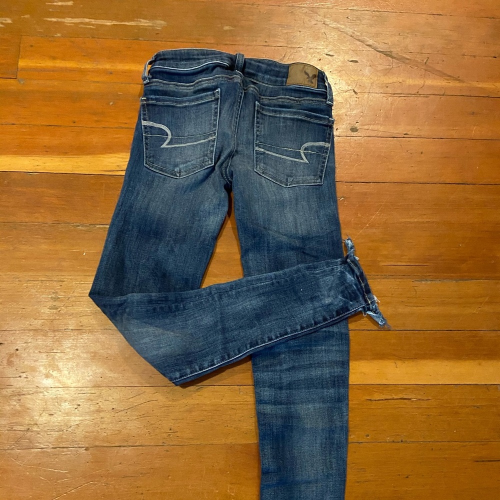 Blue jeans with distressed ankles